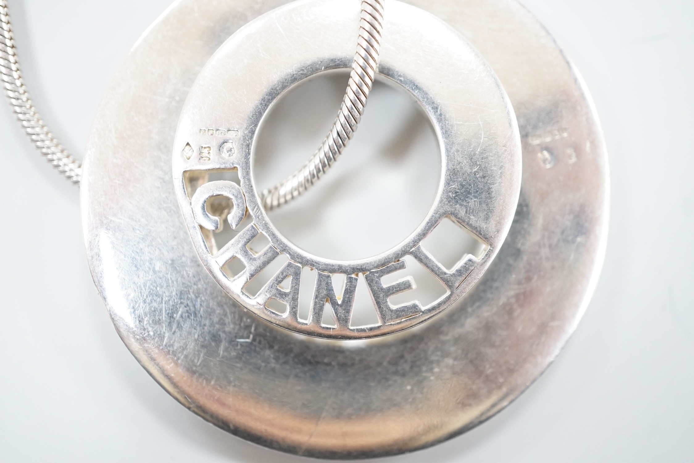 A French silver Chanel graduated double disc pendant necklace, on snake link chain, London import marks for 2001, diameter 44mm, 46.8 grams.